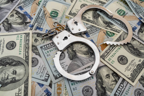 istock handcuffs on  american hundred dollar bills 1300454833