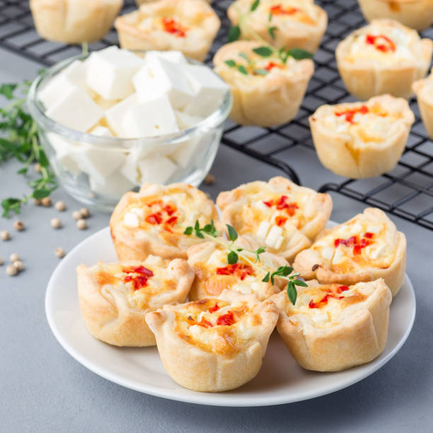 istock Feta cheese and fried onion mini quiche muffins, on white plate and cooling rack, square format 1300455238