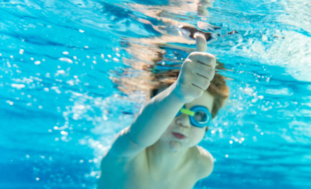 istock Boy whit thumb up swimming under water 1300455322