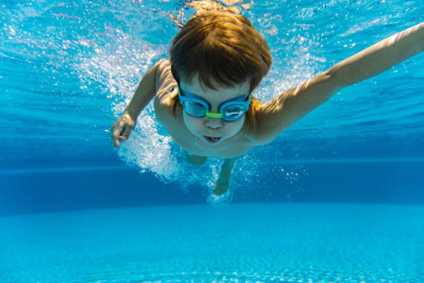 istock Little boy is diving in swimming pool 1300455497