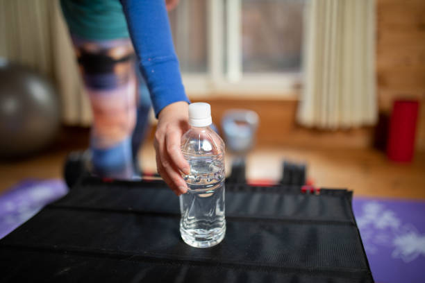 istock Close up of a water bottle with a hand reaching for it during workout 1300456713