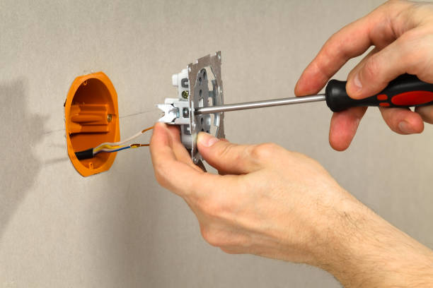 istock hands with screwdriver connect the electrical outlet to the mains 1300457398