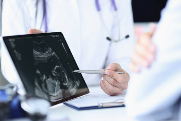 Doctor demonstrates fetal ultrasound on tablet screen. Medical examination during pregnancy concept