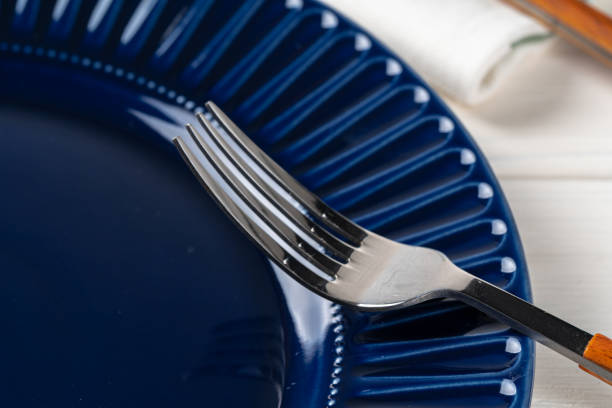 istock Deep blue ceramic plate with cutlery close up 1300457677