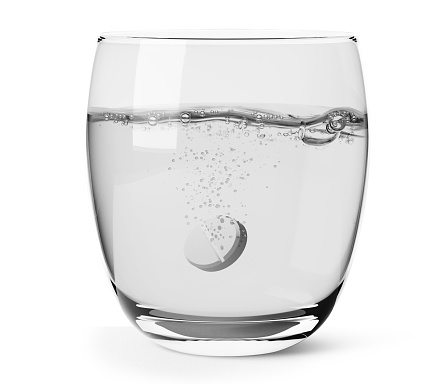 vaso de agua limpia con píldora de aspirina aislada en blanco photo
