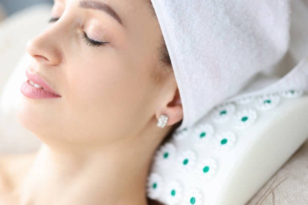 istock Woman with towel on her head lying on cushion under her neck 1300457920