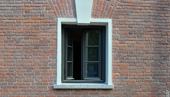 Red brick wall of the house and open window
