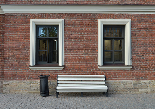 Red brick wall and white bench