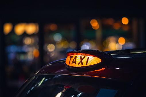 London black cab taxi sign at night