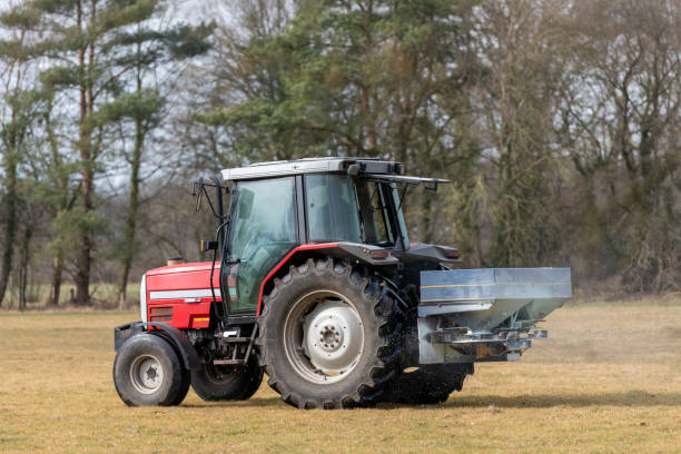 istock Red tractor on a pasture with a lime spreader in the early spring in the Netherlands 1300462735