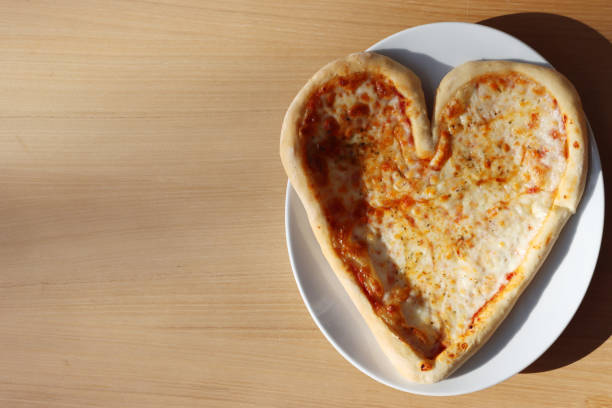 istock Heart shaped italian Pizza on table 1300464386