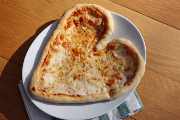 istock Heart shaped italian Pizza on table 1300464392