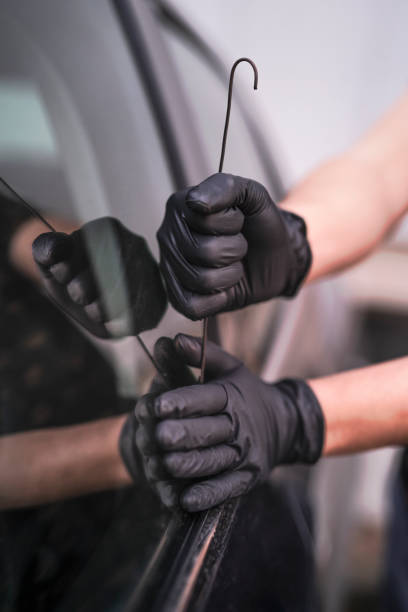 istock Car thief, male using a tool to break into a car. 1300465668