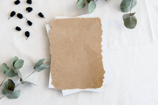 istock An empty vertical greeting card, a string of pearls and dried flowers isolated on a white table background. Top view blank for invitation 1300467387