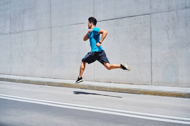 istock Athletic man sprinting running on city street 1300467404