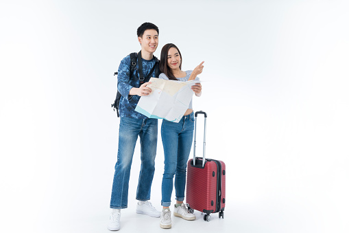 Young couple packing for vacation travel on isolated. Young Asian man and women are preparing for the journey happily on white background.