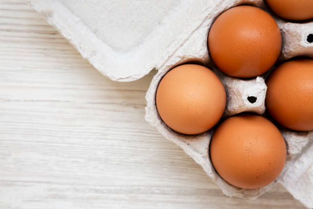 istock Raw Brown Eggs in a paper box, top view. Flat lay, overhead, from above. Space for text. 1300469054