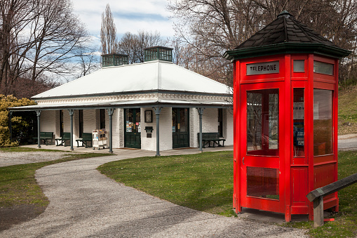 Horizontal shot of a red telephone booth by the public library of the historic gold mining town, Arrowtown, South Island, New Zealand