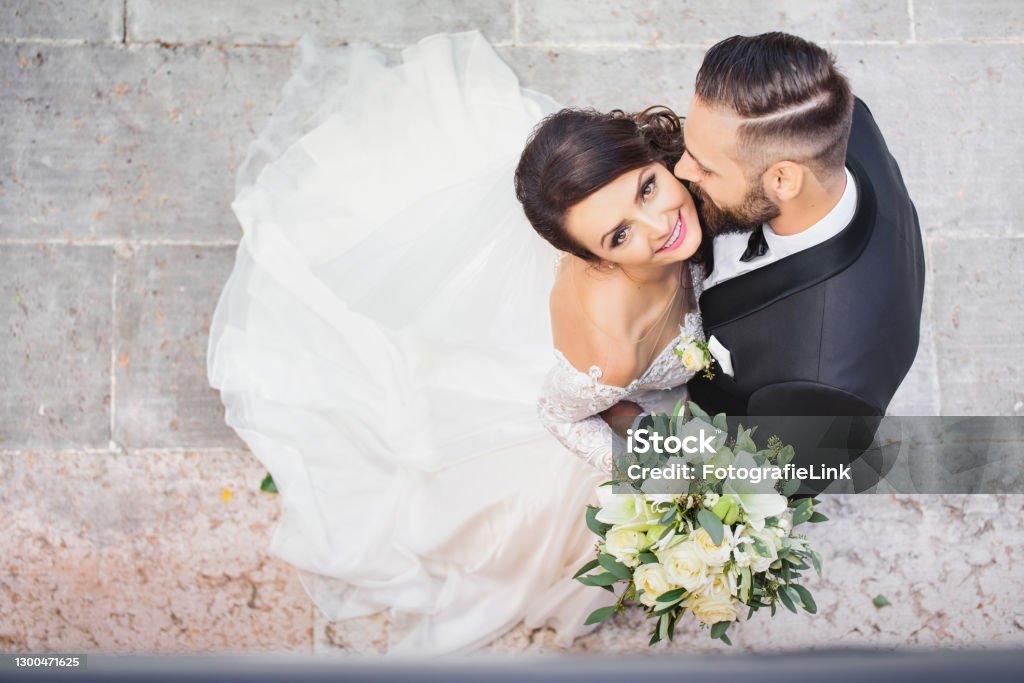 Beautiful wedding couple cuddling on their wedding day Wedding Stock Photo