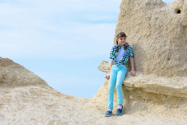 istock A ten-year-old girl sat down on a rock ledge resting after climbing 1300471704
