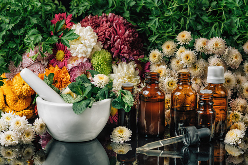 Bach Flower Remedies - Alternative Herbal Medicine. Dropper bottles, flowers, and mortar and pestle full of fresh mint