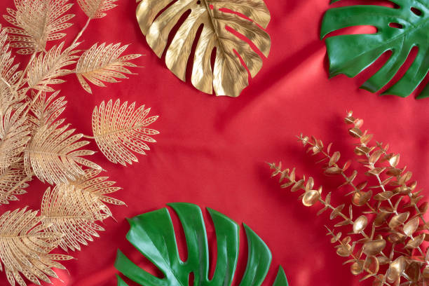 Gold leaves plant tropical monstera and palm pattern frame on a red background.