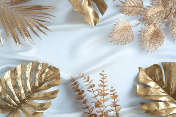 Gold tropical palm leaves Monstera on white background. Flat lay
