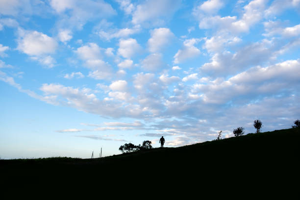 Silhouette of a man climbing the hill