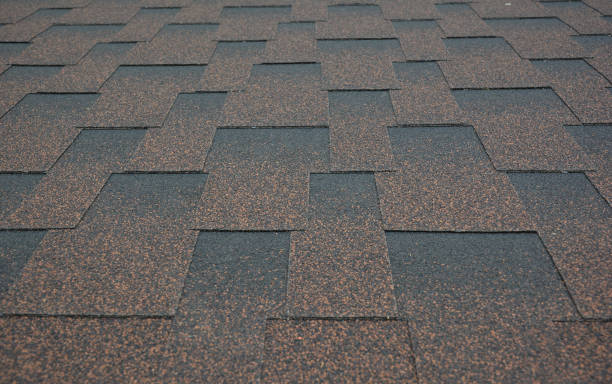 istock Asphalt shingles textured background. A close-up on copper brown dimensional, or architectural roofing asphalt shingles background. 1300474438