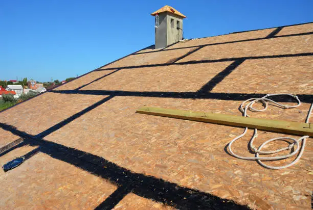 Photo of A close-up on an incomplete roofing construction on the stage of roof sheathing with self-adhering rubberized asphalt flexible flashings installed.