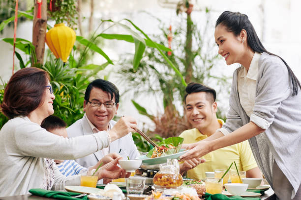 istock Woman offering salad to guests 1300475598