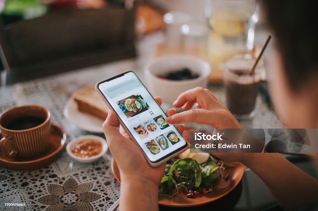 high angle view asian chinese woman's hand on mobile app for online   food delivery during breakfast time Healthy Eating Stock Photo
