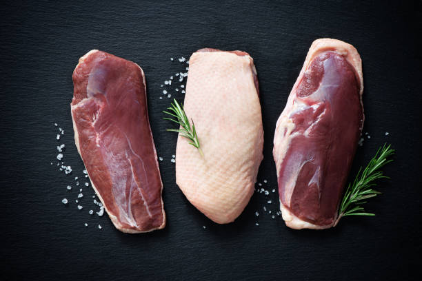 istock Raw duck breast pieces on dark slate background 1300477395