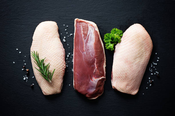 istock Raw duck breast pieces on dark slate background 1300477402