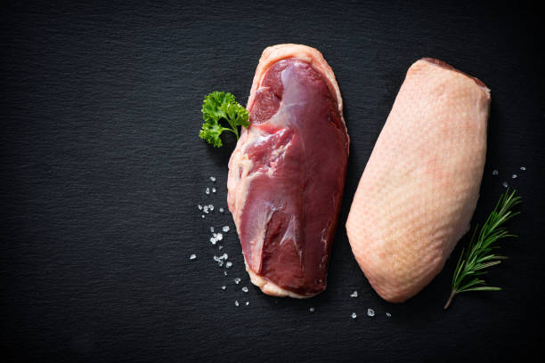 istock Raw duck breast pieces on dark slate background 1300477429