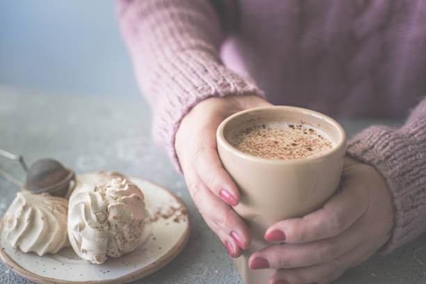 istock Women in a warm sweater hold a cup coffee or cocoa. 1300479005