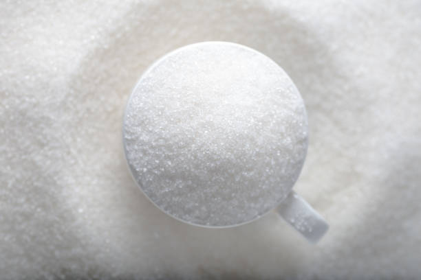 istock White granulated sugar in a white cup on a pile of sugar 1300479831