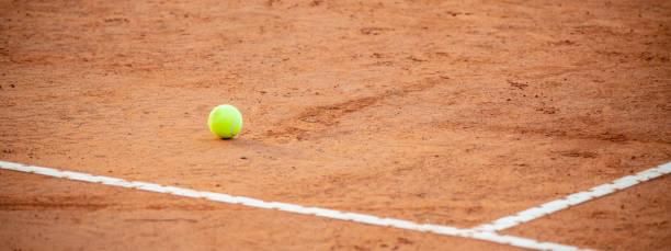 istock Tennis ball close up on red clay courts 1300480027