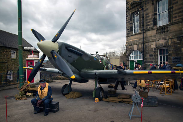 World War II – Home Front Crich, England - April 17, 2017: Spitfire airplane at the World War II - Home Front 1940s event at the Crich Tramway Village in Derbyshire. The event included historic road and military vehicles and people in 1940s costume. Visitors could also ride the vintage trams of the National Tramway Museum. spitfire stock pictures, royalty-free photos & images