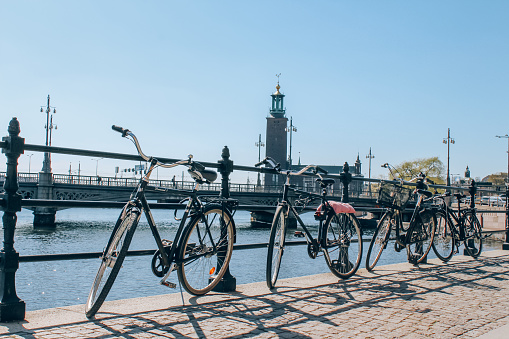 Stockholm, Sweden - May 1, 2019 : Scenic sunny day panorama of city quay with bicycles and City Hall, The Old Town in Stockholm. City tour concept and spring vacation in Sweden, selective focus