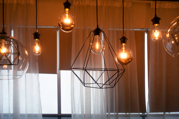 Light bulbs hanging from ceiling Light bulbs hanging from ceiling with Modern dining room light fixture stock pictures, royalty-free photos & images