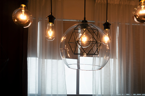 Chandelier with lamps. Light in interior. Antique glass chandelier. Ceiling in hall.
