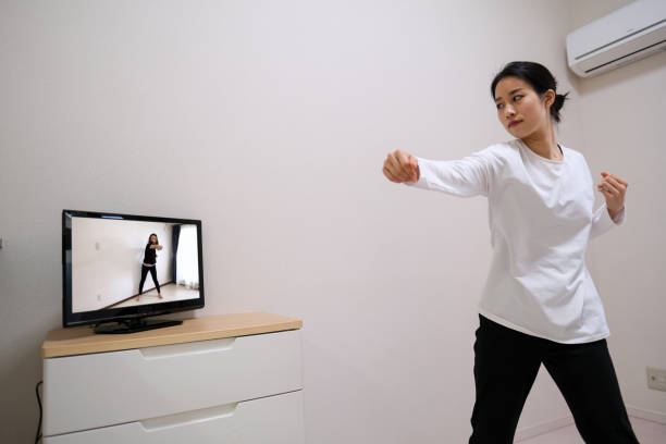 istock Young woman exercising with watching youtube 1300487673