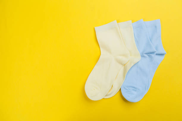 istock Multi-colored socks on a yellow background. View from above. Many different socks for cold seasons 1300488337