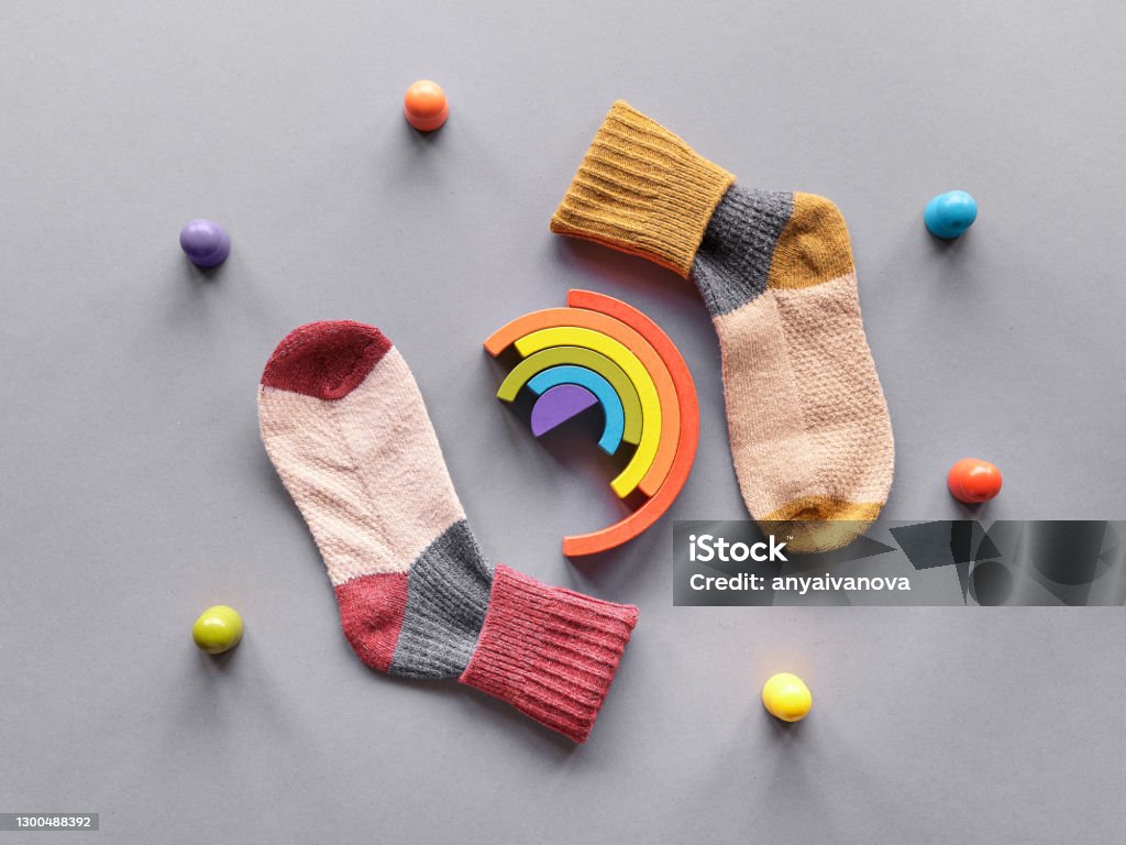 Odd Socks Day.Mismatched socks, wooden rainbow and toy figures. Social initiative against bullying in school or workplace. Design for anti-bullying campaign poster Odd Socks Day. Mismatched socks, wooden rainbow and toy figures. Social initiative against bullying in school or workplace. Design for anti-bullying campaign poster or cards. Above Stock Photo