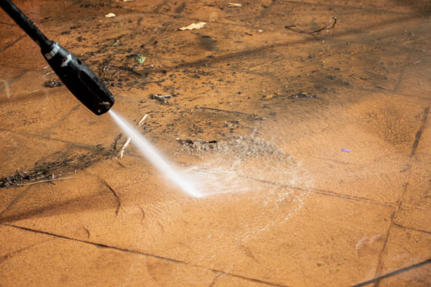 istock Cleaning backyard paving tiles with pressure washer. 1300489063