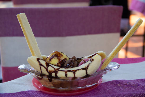 istock delicious banana split on glass plate on pink and white background 1300489250