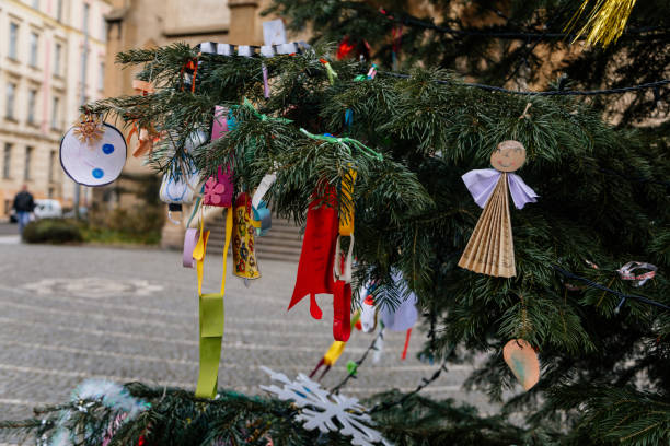 Handmade toys for Christmas tree decoration, an asterisk on green branches outdoors, toy made of wood, plaster and glitters, Environment, recycle, upcycling and zero waste concept. Selective focus juguetes hechos a mano para la decoración de árboles de navidad, un asterisco sobre ramas verdes al aire libre, juguete hecho de madera, yeso y purpurinas, medio ambiente, reciclaje, upcycling y concepto de residuos cero. enfoque selectivo