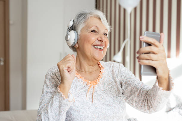 istock Senior woman in bedroom using smart phone 1300490100