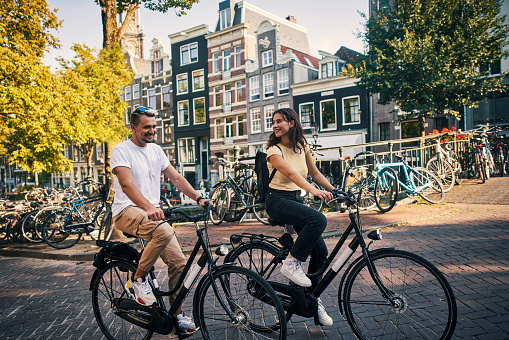 Shot of a young couple exploring the city of Amsterdam by bike